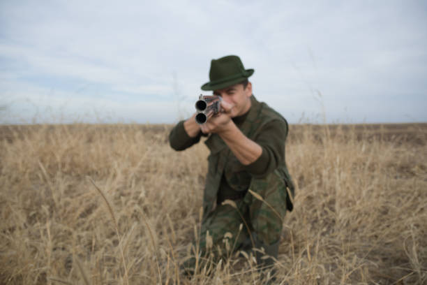 istock Hunter aiming with riffle shotgun on the field 1084877882