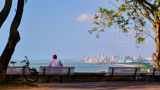 Olinda, Pernambuco, Brazil - September 23, 2017:Man sitting on a bench, enjoying from view from Olinda city