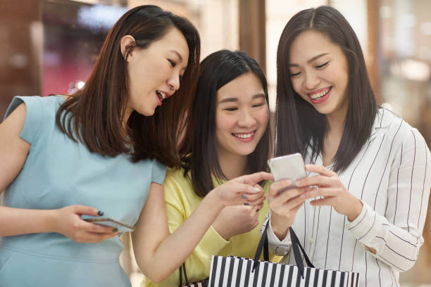 istock Cheerful women using mobile phone in shopping mall 1084889022