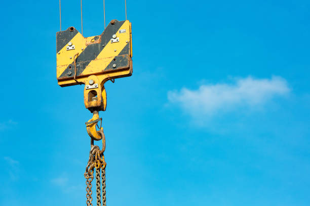 istock Crane load hook against the sky with trails and chain. 1084900880
