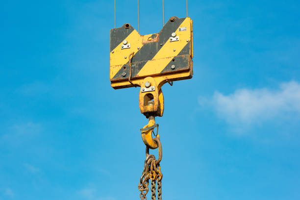 istock Crane load hook against the sky with trails and chain. 1084900930