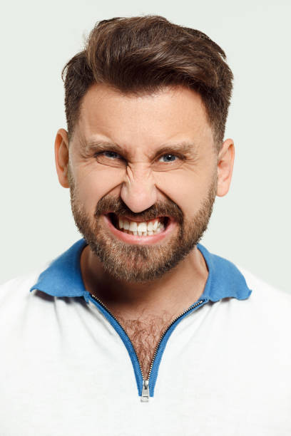 istock The young emotional angry man screaming on studio background 1084901426