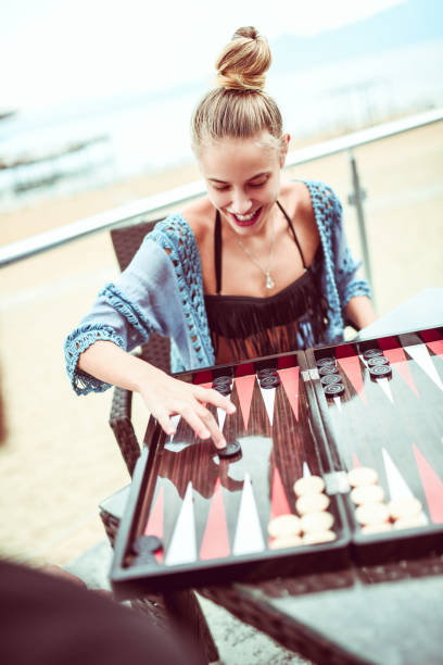 istock Cute Blonde Playing Backgammon At The Beach 1084907244