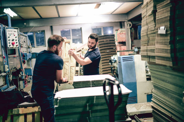 istock Bearded Colleagues Working In a Team On a Night Shift In Cardboard Factory 1084911378