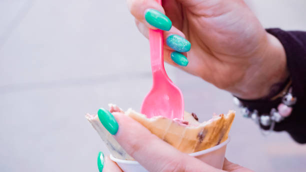 istock Moman with blue nails eating ice cream outside. 1084912190