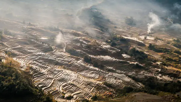 A shot of a section of a rice terrace at Yuanyang - Yunnan, China during late afternoon. Farmers do sometimes burnt leftover crops.