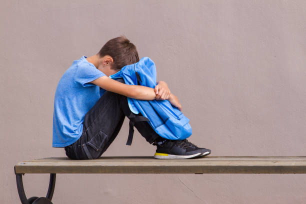 istock Sad, tired child sitting alone on the bench outdoors. 1084922980