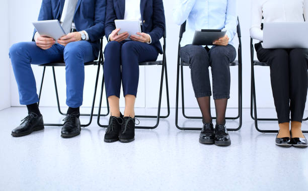 istock Group of business people sitting in office and waiting for job interview while using gadgets, close-up. Conference or training concepts 1084931146
