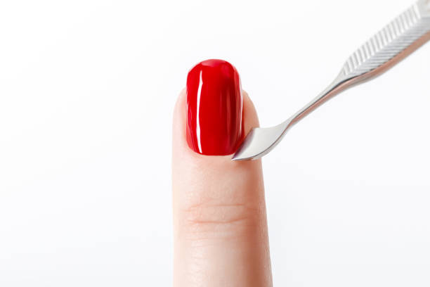 istock bright red nail polish on fingernail with cuticle pusher isolated on white 1084934742