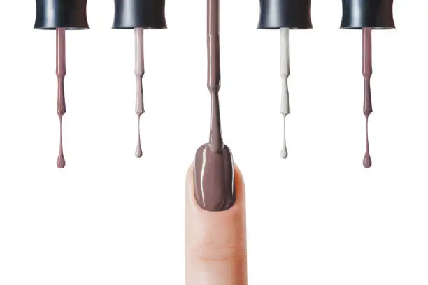 brown nail polish on fingernail with wet brush isolated on white