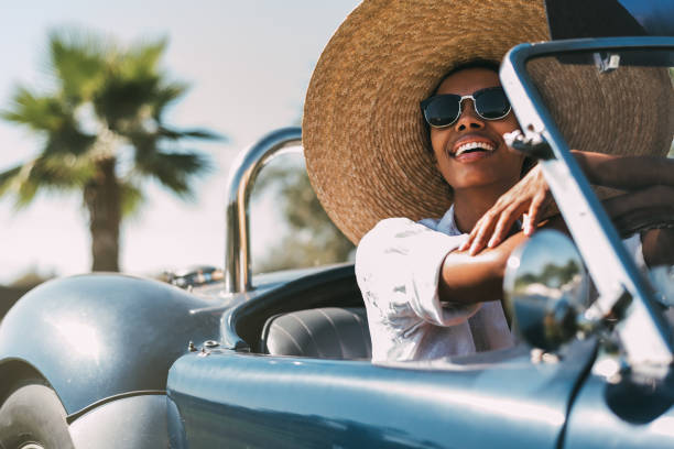 Black woman driving a vintage convertible car stock photo