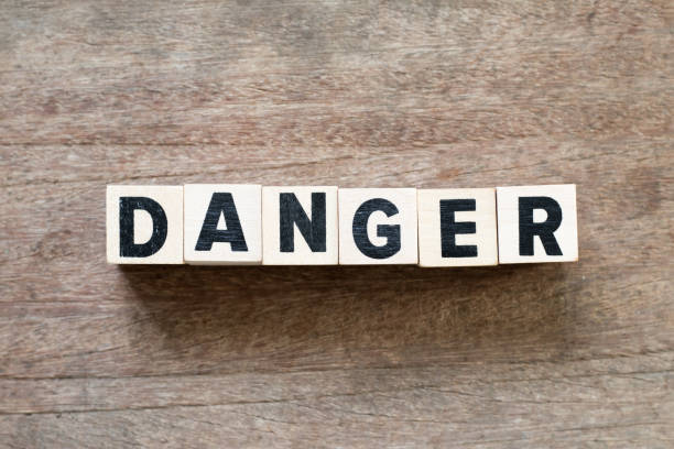 istock Letter block in word danger on wood background 1084957488