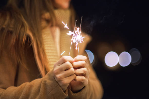 schöne frau, die spaß mit wunderkerze in ihren händen feiert silvester - sparkler sparks new years eve human hand stock-fotos und bilder