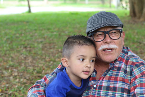 tierna imagen de abuelo con su nieto - whispering grandparent child grandfather fotografías e imágenes de stock