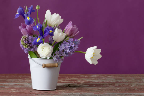 istock spring flowers in bucket on pink background 1084970270