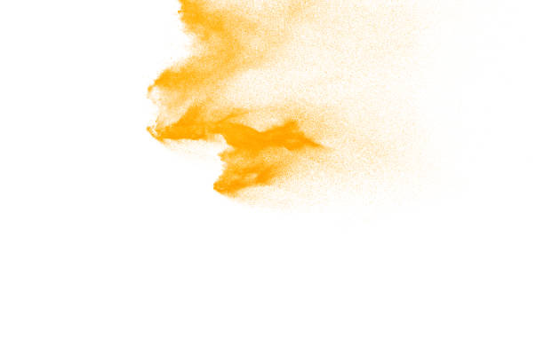 istock Yellow particles explosion on white background. Freeze motion of yellow dust splash on background. 1084970574