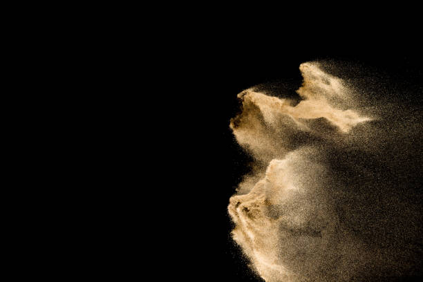 istock Golden sand explosion isolated on black background. Abstract sand cloud. 1084970586
