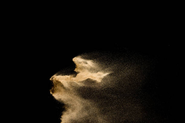 istock Golden sand explosion isolated on black background. Abstract sand cloud. 1084970612
