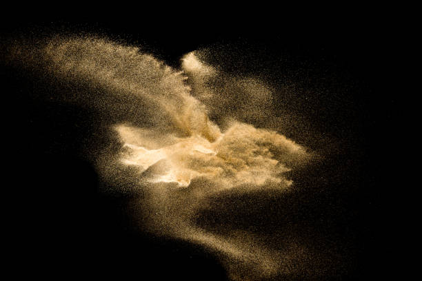 istock Golden sand explosion isolated on black background. Abstract sand cloud. 1084970648