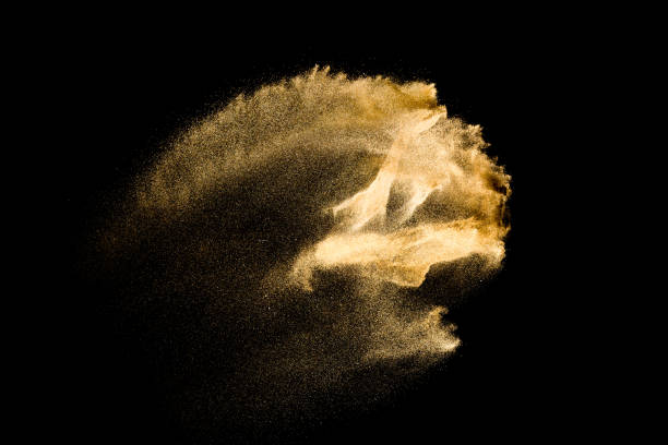 istock Golden sand explosion isolated on black background. Abstract sand cloud. 1084970684