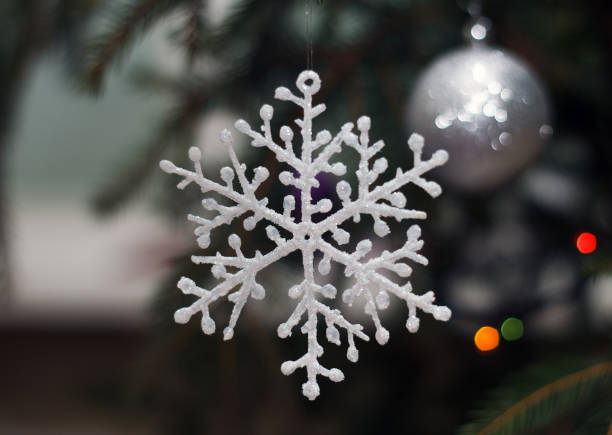 istock New Year's decorative snowflake hanging on a fir-tree branch 1084971380