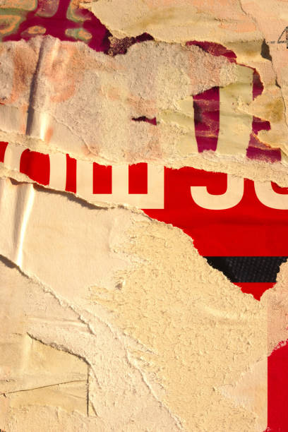 Pieces of torn paper peeling off wall used as billboard