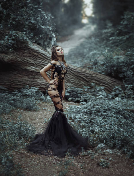istock Seductive dark queen magician in a luxurious, black dress - web. 1084974328