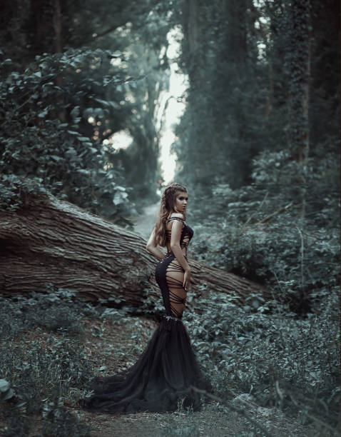 istock Seductive dark queen magician in a luxurious, black dress - web. 1084974504
