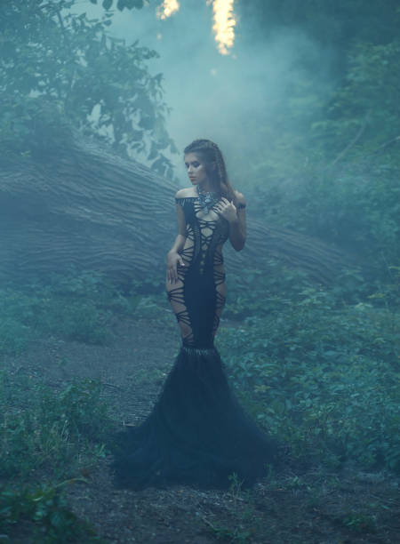istock Seductive dark queen magician in a luxurious, black dress - web. 1084974540