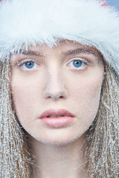 istock Frozen girl with snow on face wearing Santa hat 1084976192