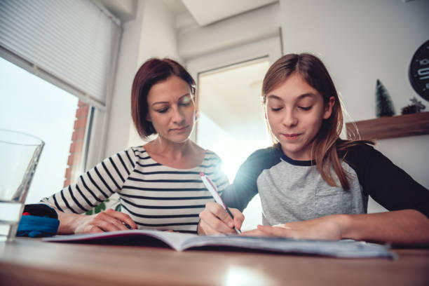 istock Mother helping daughter to finish homework 1084981950