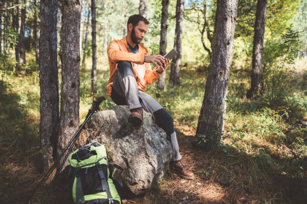 istock Tourist hiking among nature and using tablet while resting 1084985954