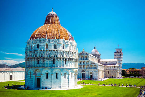 baptistery of st. john on square of miracles, leaning tower, famous inclined tower of pisa with green lawn in pisa, tuscany, italy. - giovanni boccaccio imagens e fotografias de stock