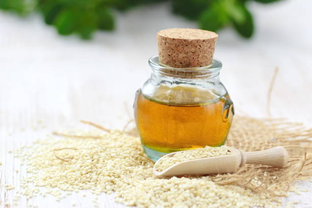 istock Sesame oil in glass and seeds 1084993192