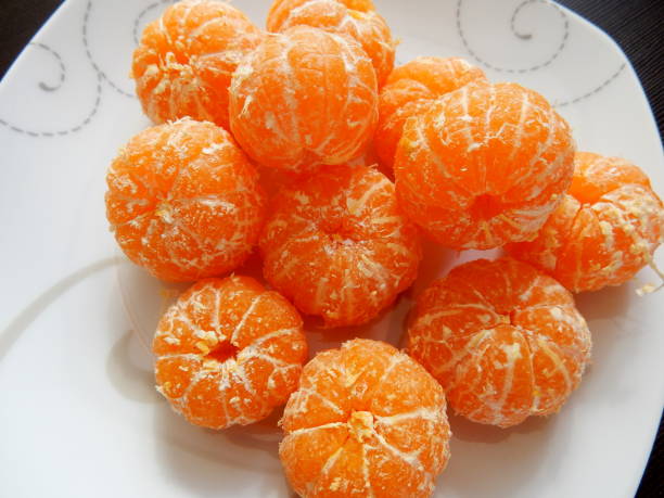 istock Peeled tangerines on a white plate 1084995930