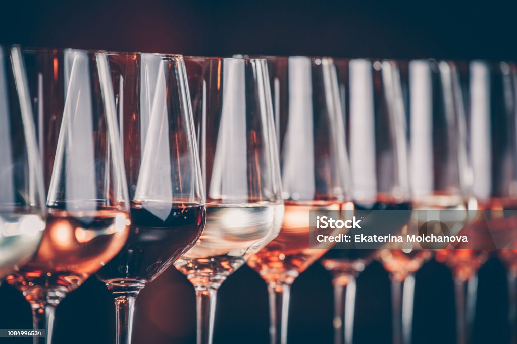 Wine glasses in a row. Buffet table celebration of wine tasting. Nightlife, celebration and entertainment concept Wine glasses in a row. Buffet table celebration of wine tasting. Nightlife, celebration and entertainment concept. Horizontal, cold toned image Wine Stock Photo
