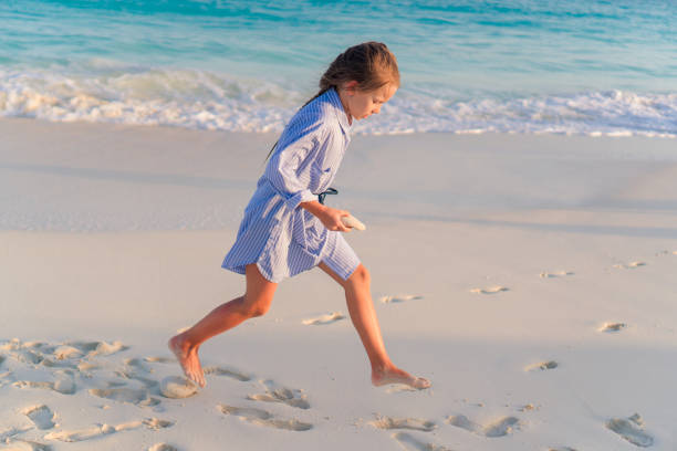 istock Little girl on white beach at sunset 1084998204