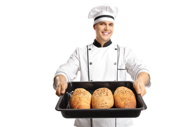 istock Young cheerful baker holding a tray of bread loafs 1084999048