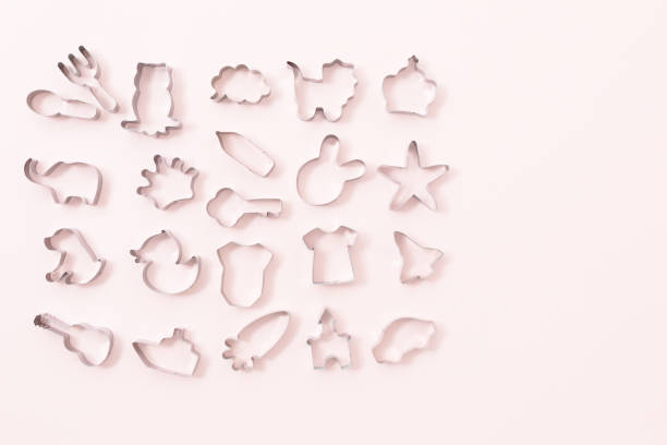 istock Cookies figures different shapes, top view, flat lay. Festive cookie cutters over white pink background. Tin biscuit cutters, tool to cut cookie dough. Figures for Easter, Christmas, child birthday 1085000742