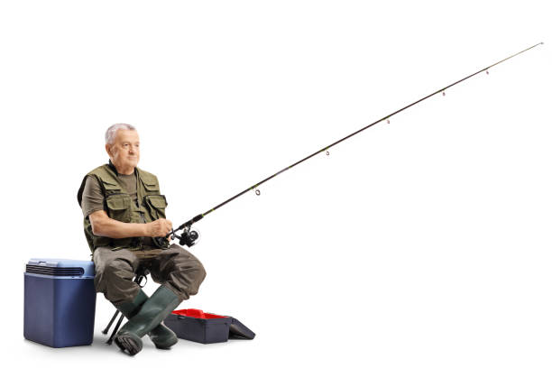 рыбак, сидящий на стуле с удочкой - crank bait стоковые фото и изображения