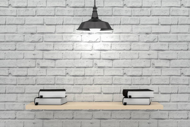 Still life photography of a hanging, lit vintage light bulb. Smudged blackboard background and books on wooden desk.