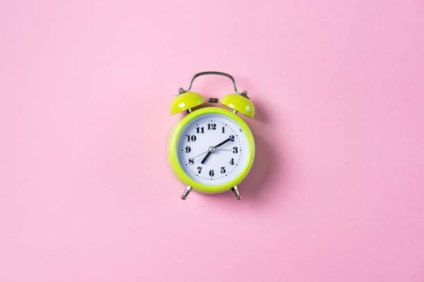 istock Green alarm clock with bells on pink background, top view with copy space 1085006032