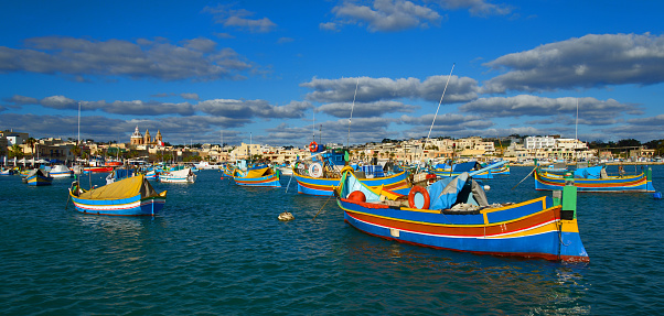The port and the citiscape of Marsaxlokk village in Malta with its characteristic colorful fishing boats
