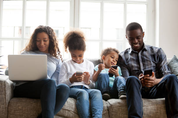 large african american family using devices, sitting together - family african ethnicity black african descent imagens e fotografias de stock