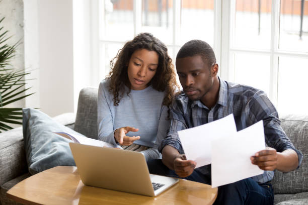 seria coppia afroamericana che discute documenti cartacei - women document looking couple foto e immagini stock