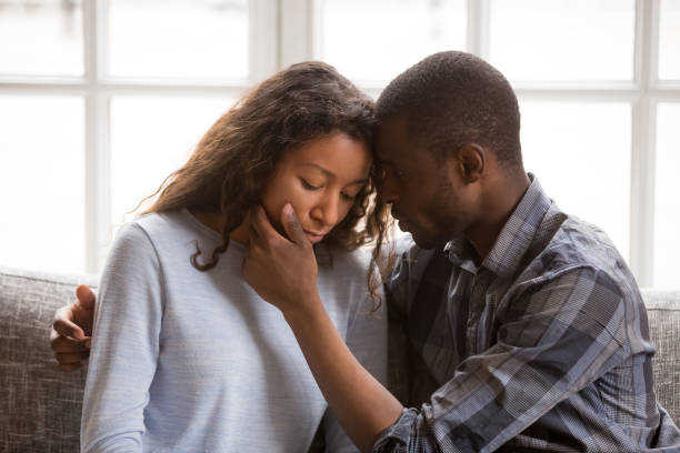 Loving African American husband touching wife face Loving African American husband touching wife face with tender, apologizing after quarrel, man comforting woman, health problem, interruption unwanted pregnancy, miscarriage, relationships trouble unwanted pregnancy stock pictures, royalty-free photos & images