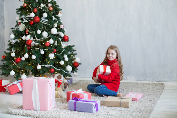 istock little girl opens Christmas presents new year tree decoration 1085016300