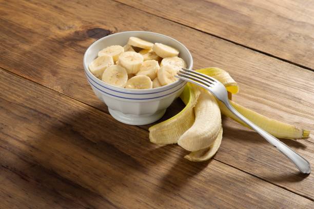 istock Banana slice on a bowl in a rustic pine wood table 1085018594