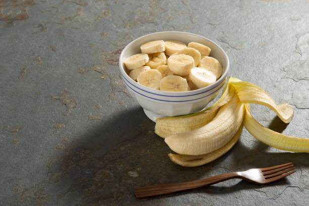 istock Banana slice on a bowl in a rustic stone table 1085018598