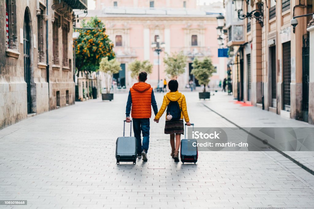 Couple traveling around the world Young couple with suitcases just arriving in Valencia Travel Stock Photo